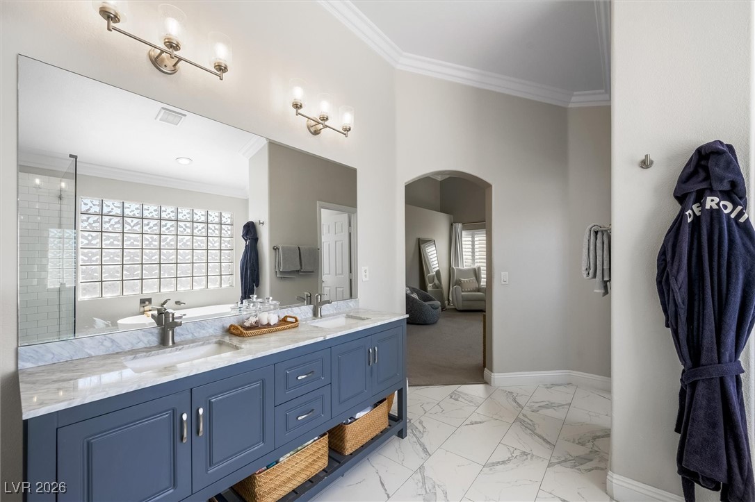 1673 Ravanusa Drive Henderson, NV 89052 - Photo 33 of 66 Full bathroom featuring crown molding, double vanity, light marble finish floors, ensuite bathroom, and a soaking tub