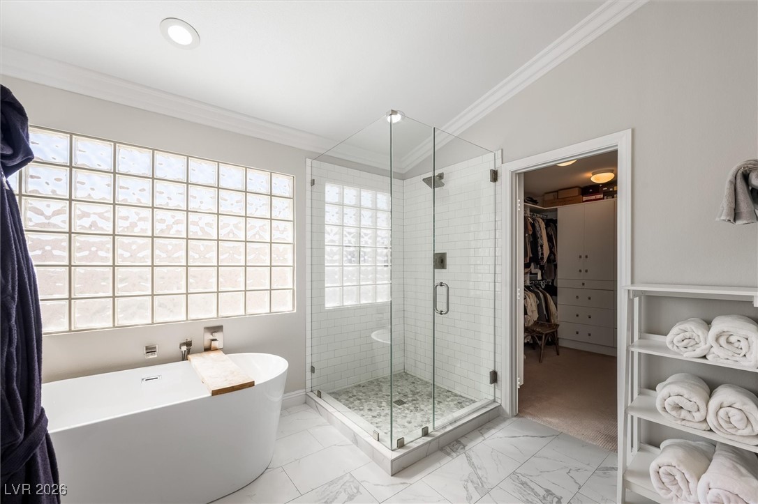 1673 Ravanusa Drive Henderson, NV 89052 - Photo 34 of 66 Full bathroom featuring a freestanding tub, a spacious closet, a shower stall, light marble finish floors, and ornamental molding