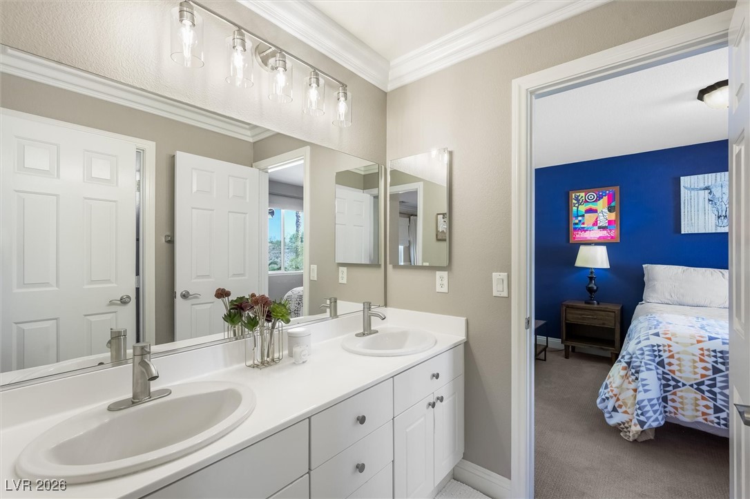 1673 Ravanusa Drive Henderson, NV 89052 - Photo 37 of 66 Jack and Jill bathroom featuring double vanity and ornamental molding
