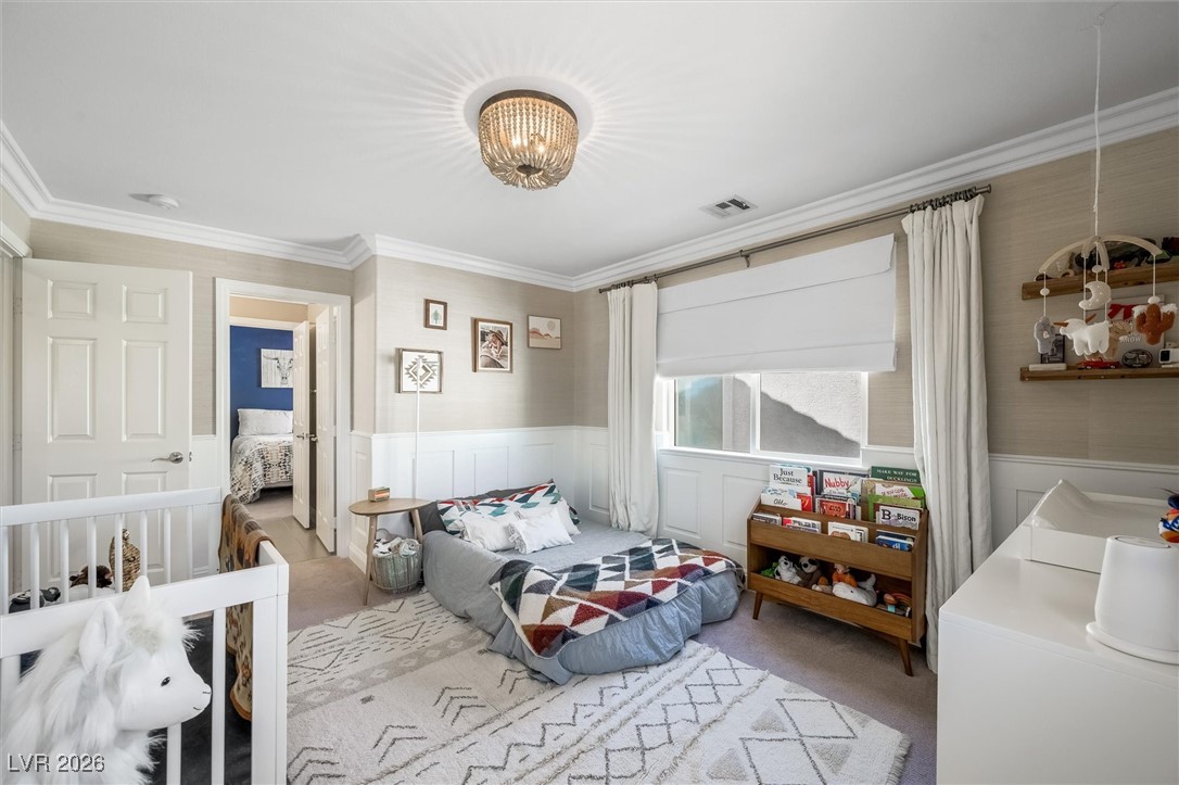 1673 Ravanusa Drive Henderson, NV 89052 - Photo 39 of 66 Bedroom with wainscoting, ornamental molding, carpet, a chandelier, and a decorative wall