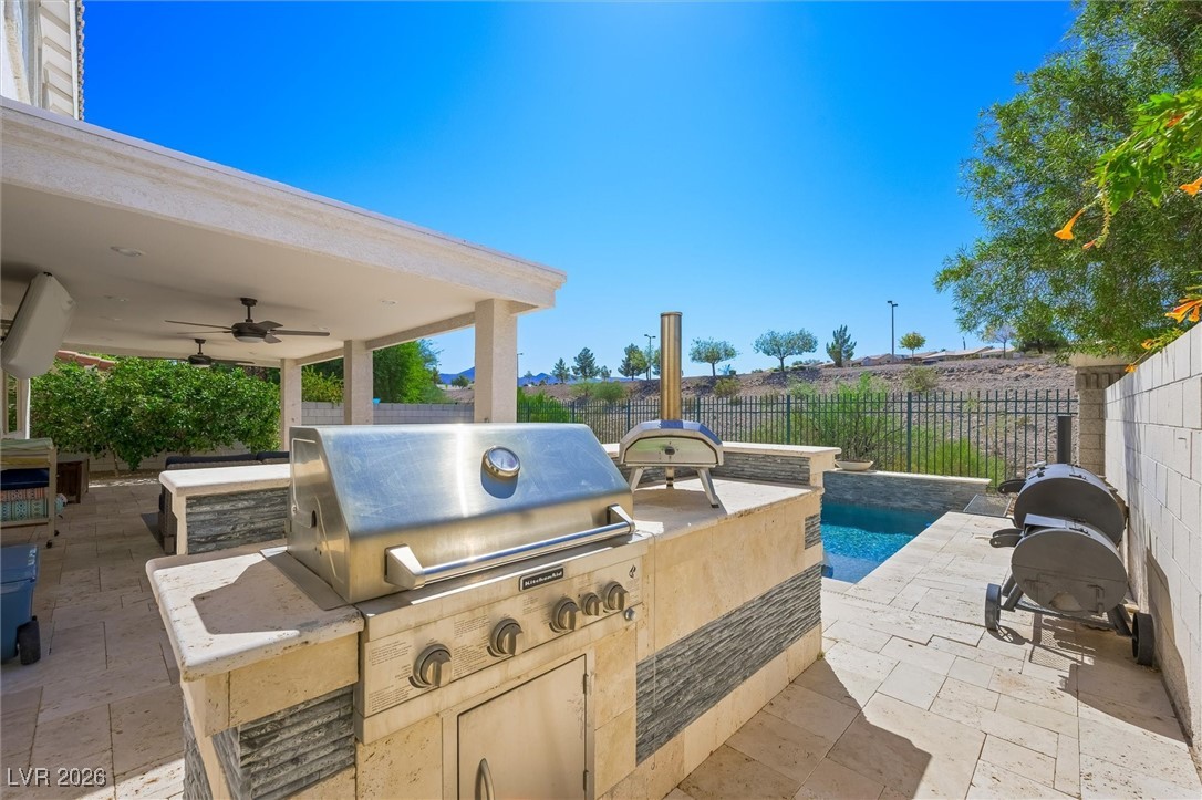 1673 Ravanusa Drive Henderson, NV 89052 - Photo 46 of 66 Fenced backyard with exterior kitchen, a patio, and ceiling fan