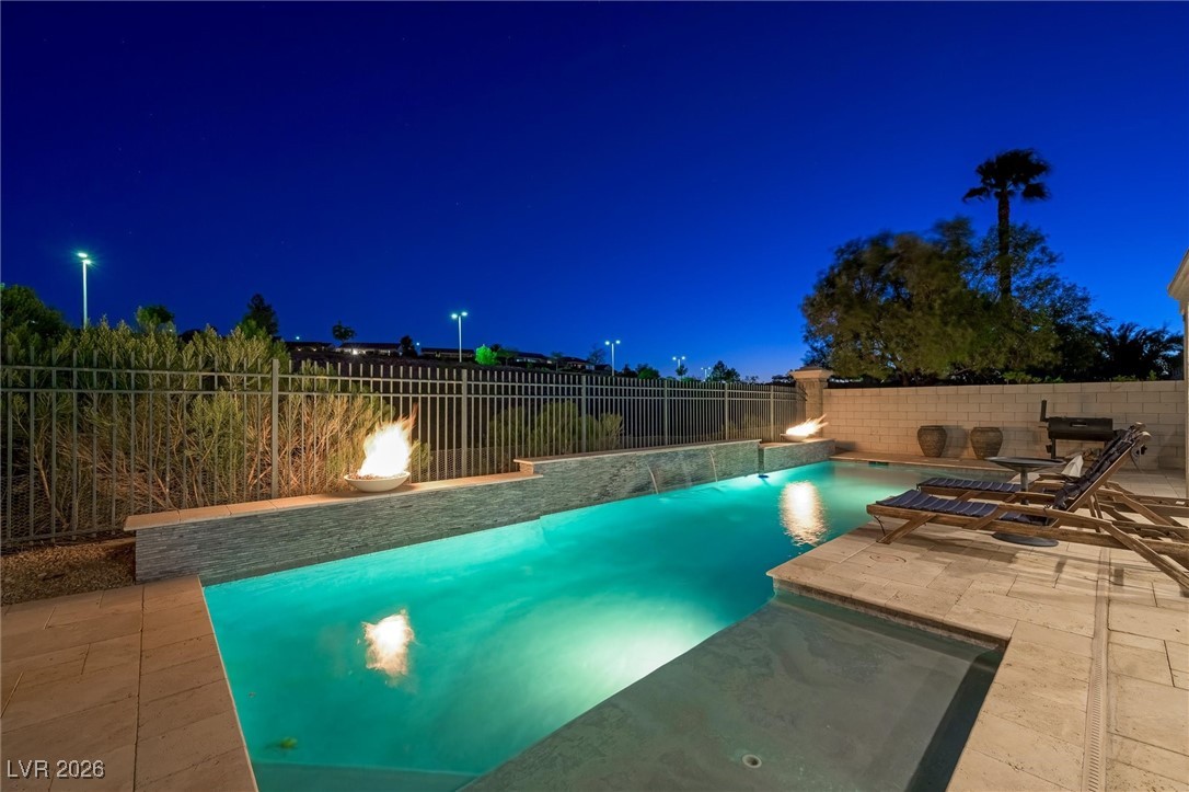 1673 Ravanusa Drive Henderson, NV 89052 - Photo 48 of 66 Pool at night with a fenced backyard and a patio area
