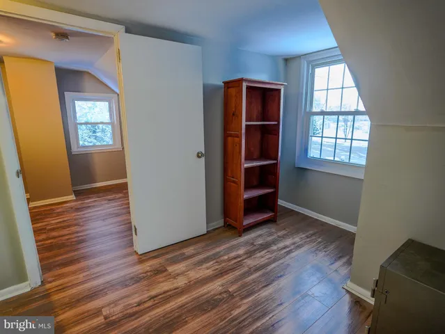 a view of a bedroom with wooden floor and a window