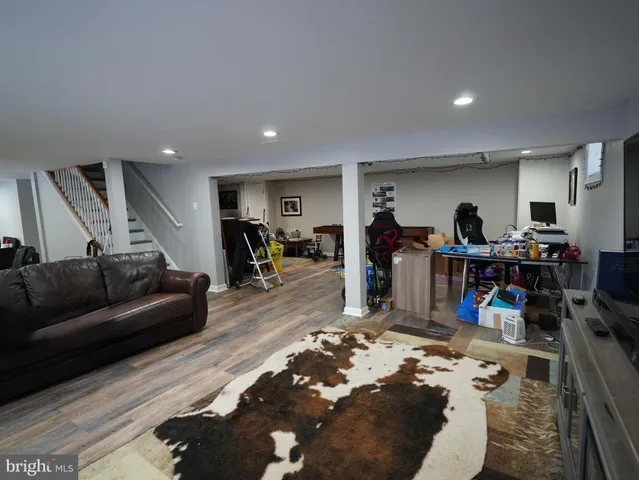 a living room with furniture and a dining table with bookshelf