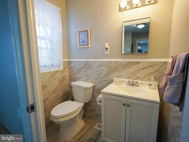 a view of a house with large trees next to a road