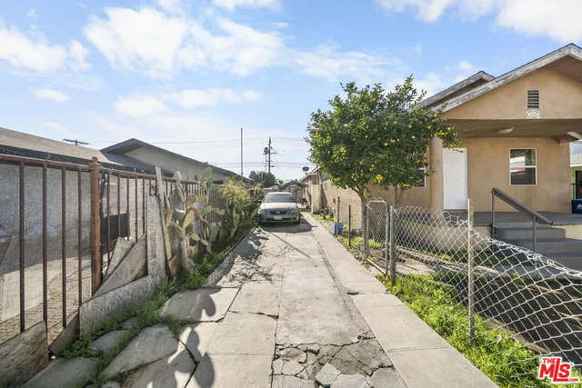 a view of a pathway of a house with wooden fence
