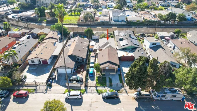an aerial view of a house with swimming pool and outdoor seating