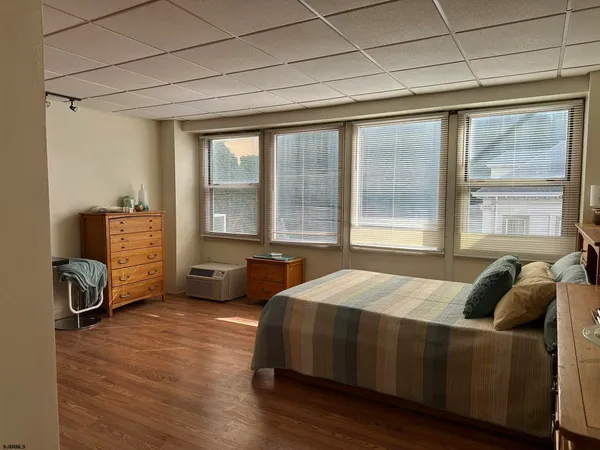 a bedroom with a bed and two windows