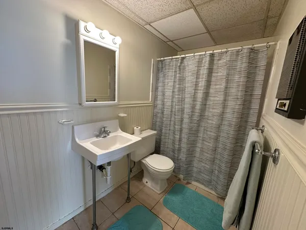 a bathroom with a sink a mirror and shower curtain