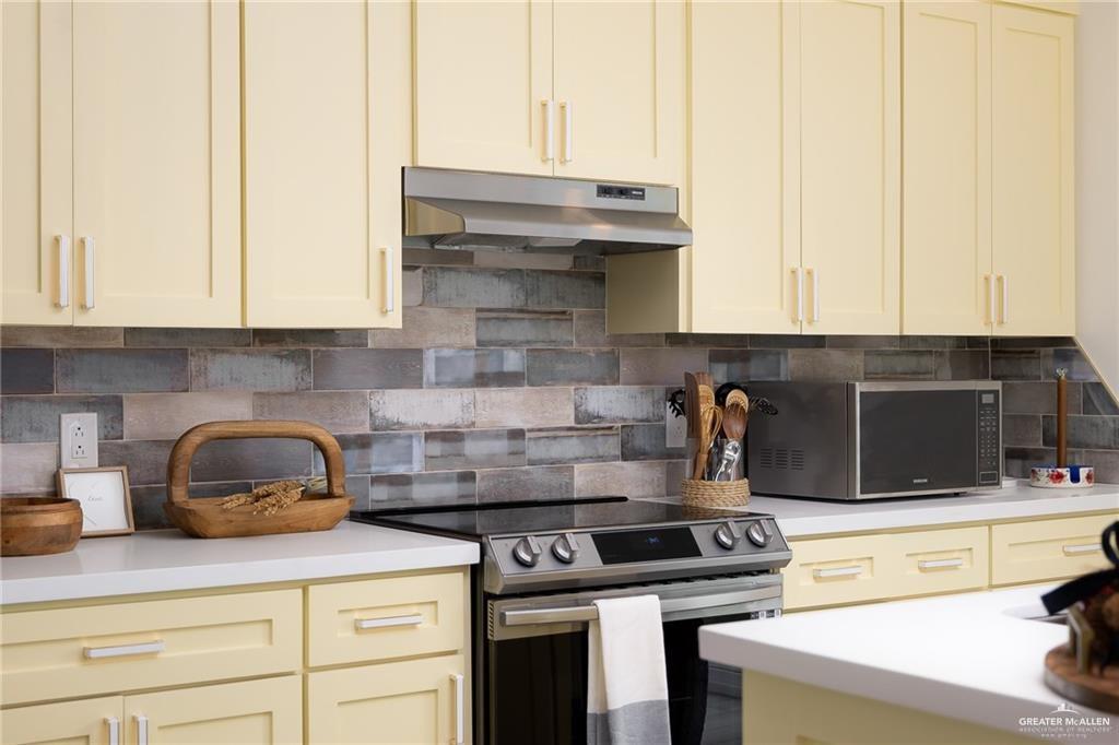 1009 Bass Avenue, Unit 1 Port Isabel, TX 78578 - Photo 11 of 19 a kitchen with stainless steel appliances granite countertop a stove and a white cabinets