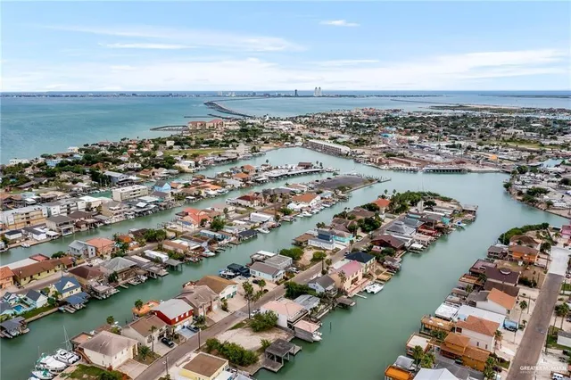 an aerial view of a city with lots of residential buildings and ocean view in back
