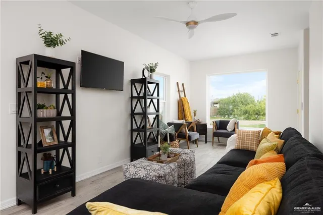 a living room with furniture tv and a window