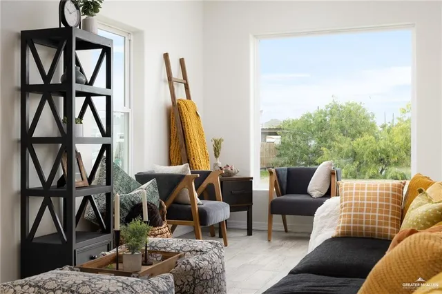a living room with furniture a window and a wooden floor
