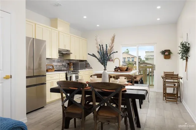 a kitchen with a table chairs refrigerator and cabinets