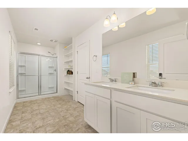 a spacious bathroom with a sink a mirror and a shower