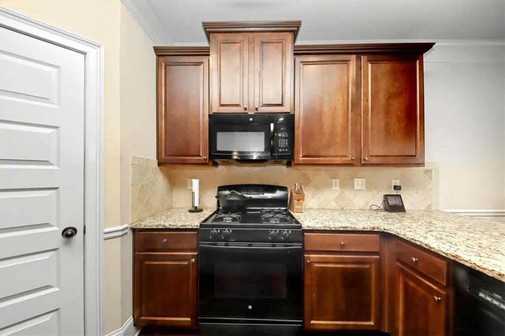 4058 Rosebay Way Southwest Conyers, GA 30094 - Photo 17 of 55 a kitchen with granite countertop a stove and a microwave