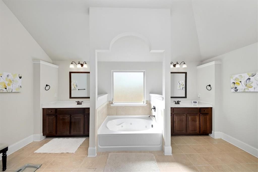 4058 Rosebay Way Southwest Conyers, GA 30094 - Photo 32 of 55 a spacious bathroom with a tub sink and mirror