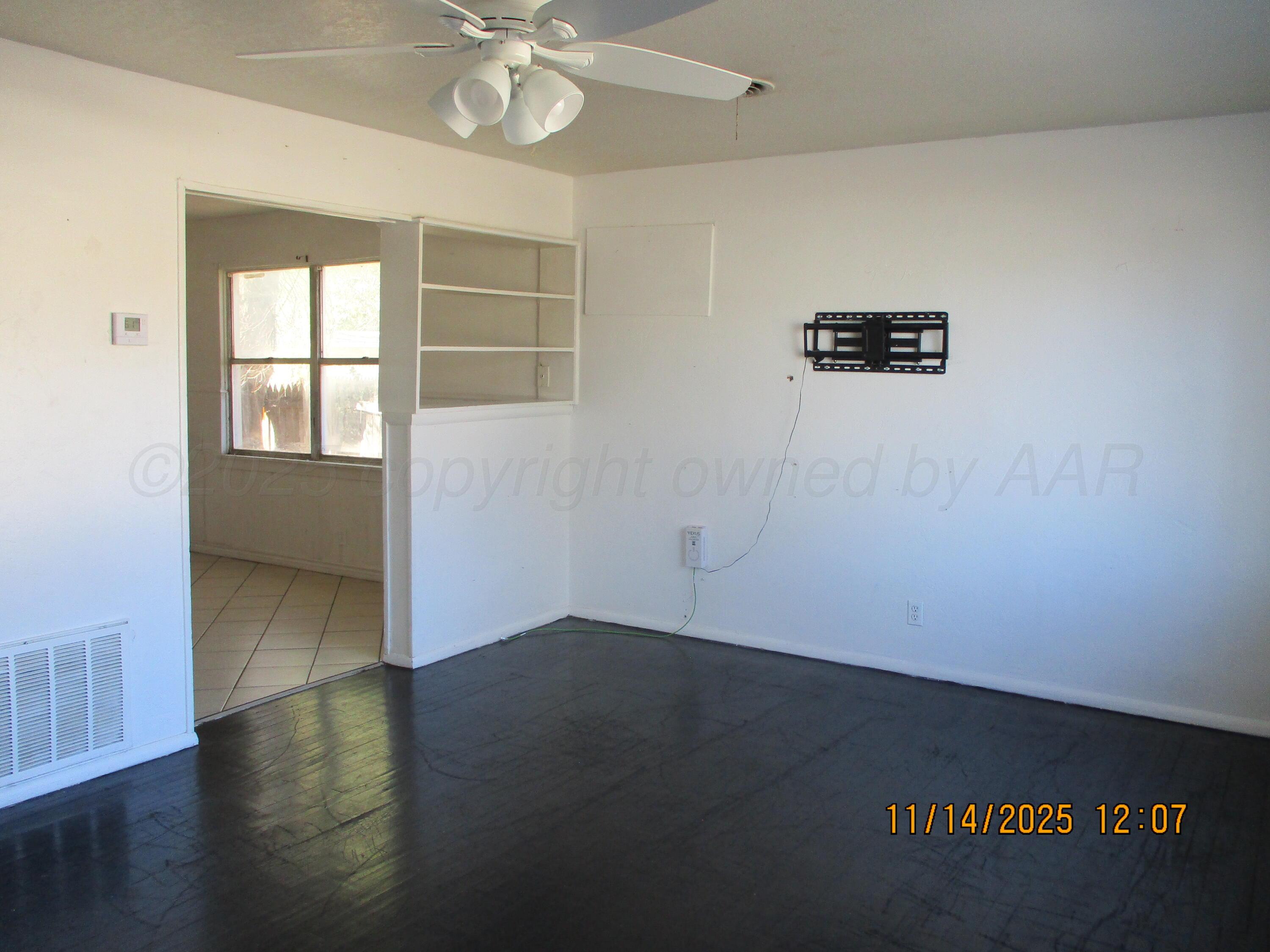 211 Southwest 34th Avenue Amarillo, TX 79109 - Photo 2 of 10 an empty room with wooden floor and windows