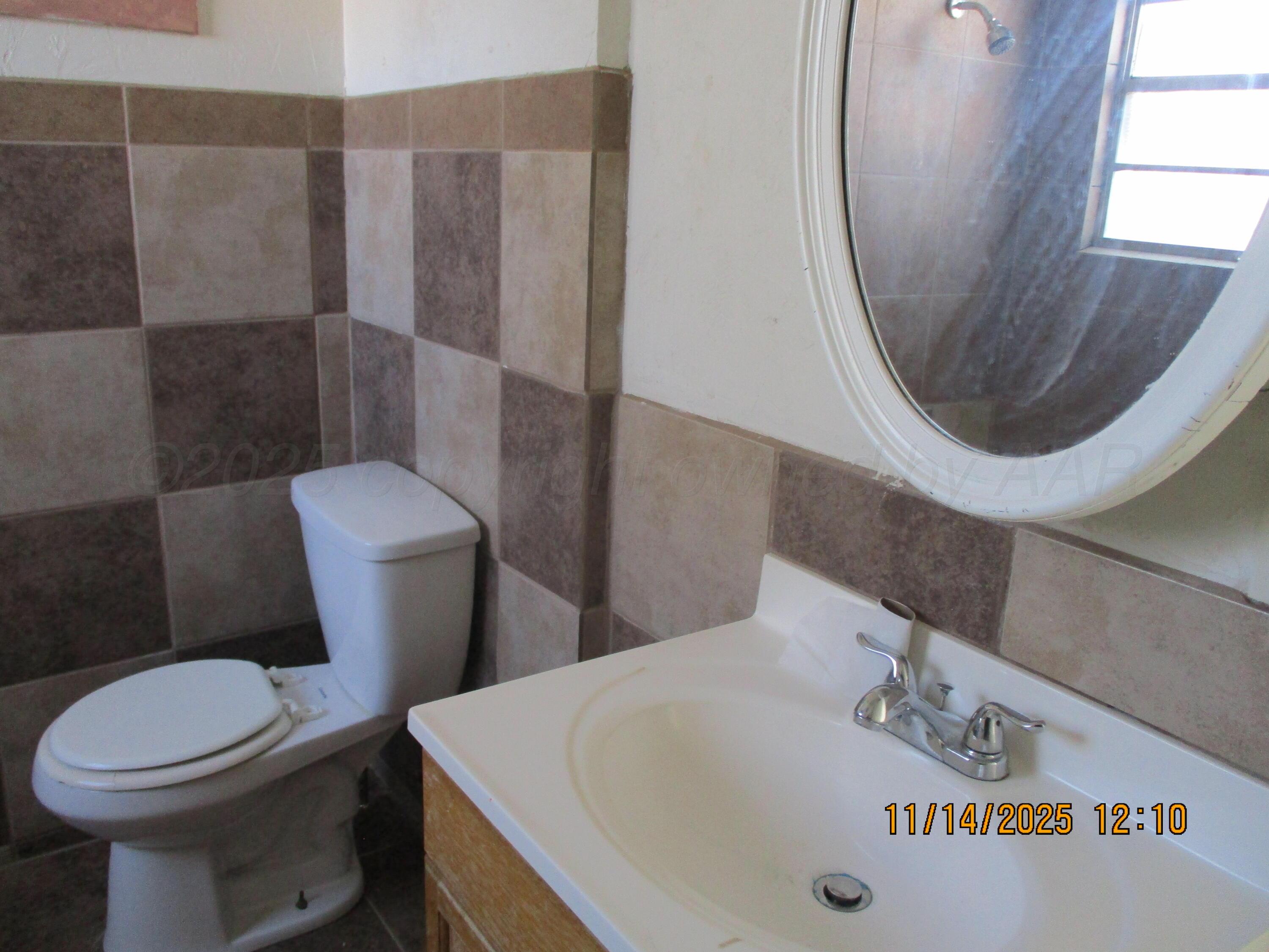 211 Southwest 34th Avenue Amarillo, TX 79109 - Photo 4 of 10 a white toilet sitting next to a bathroom sink