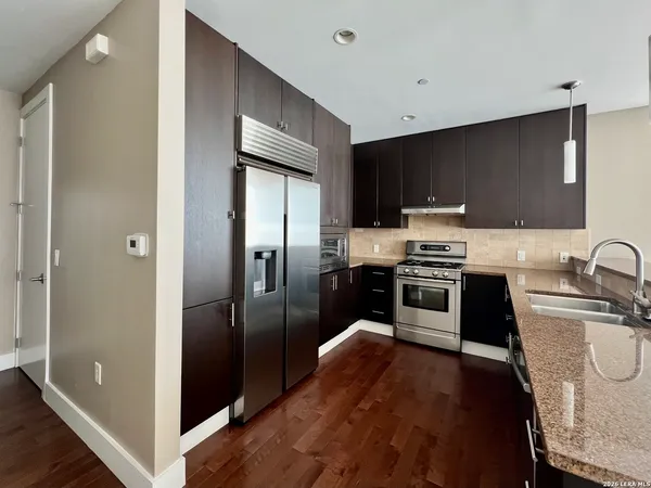a kitchen with stainless steel appliances granite countertop a refrigerator and a sink