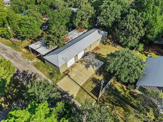 an aerial view of a house with a yard and large trees