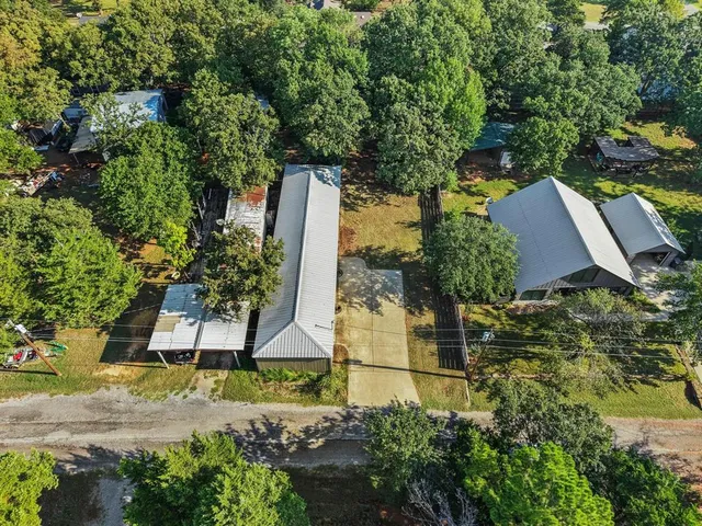 an aerial view of a house with a yard and large trees