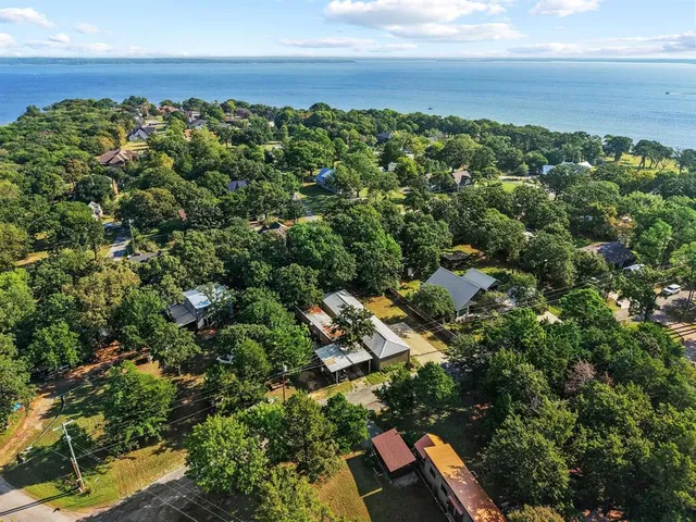 an aerial view of residential house with outdoor space and trees all around