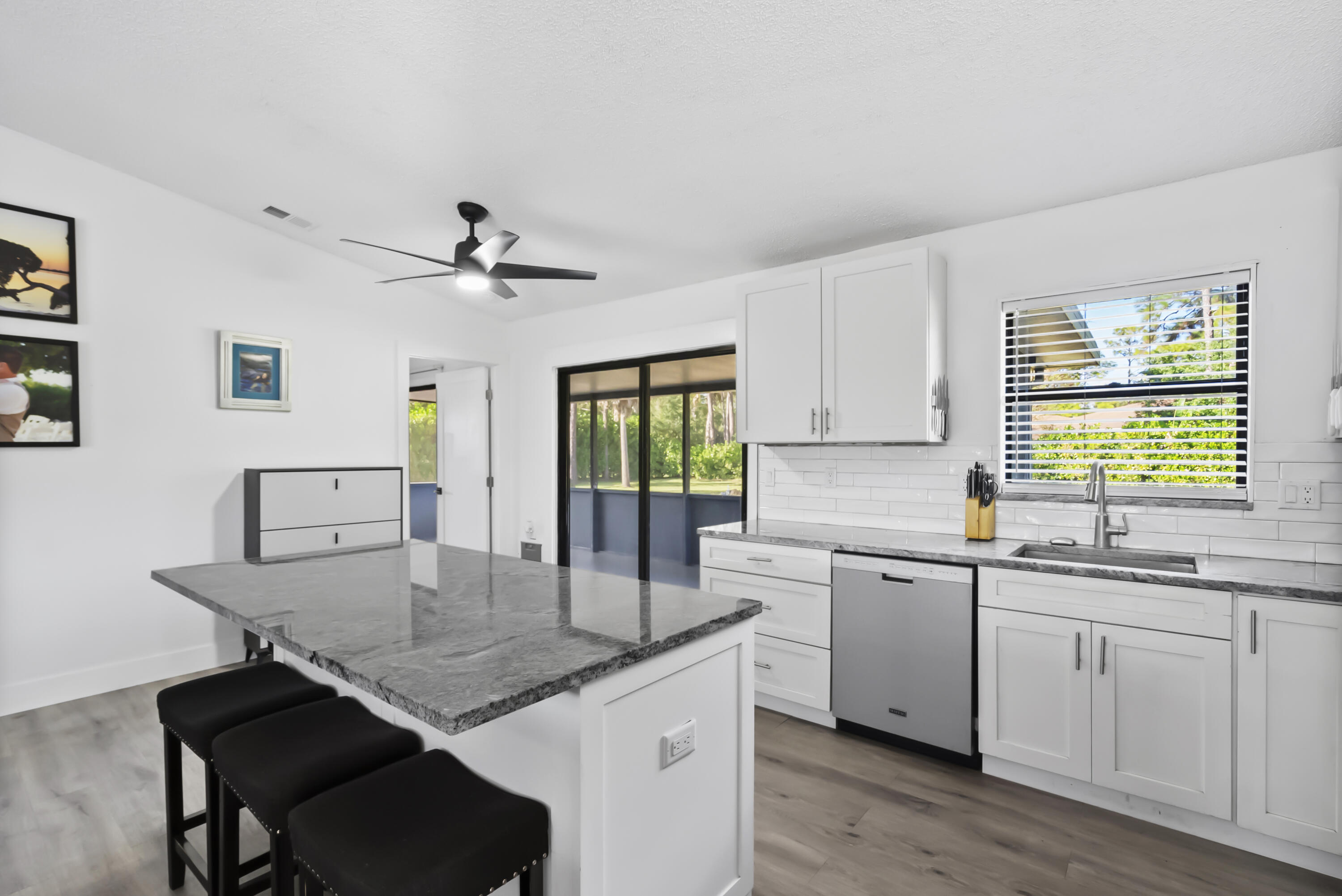 17493 41st Road North The Acreage, FL 33470 - Photo 12 of 45 a kitchen with granite countertop a sink white cabinets and wooden floor