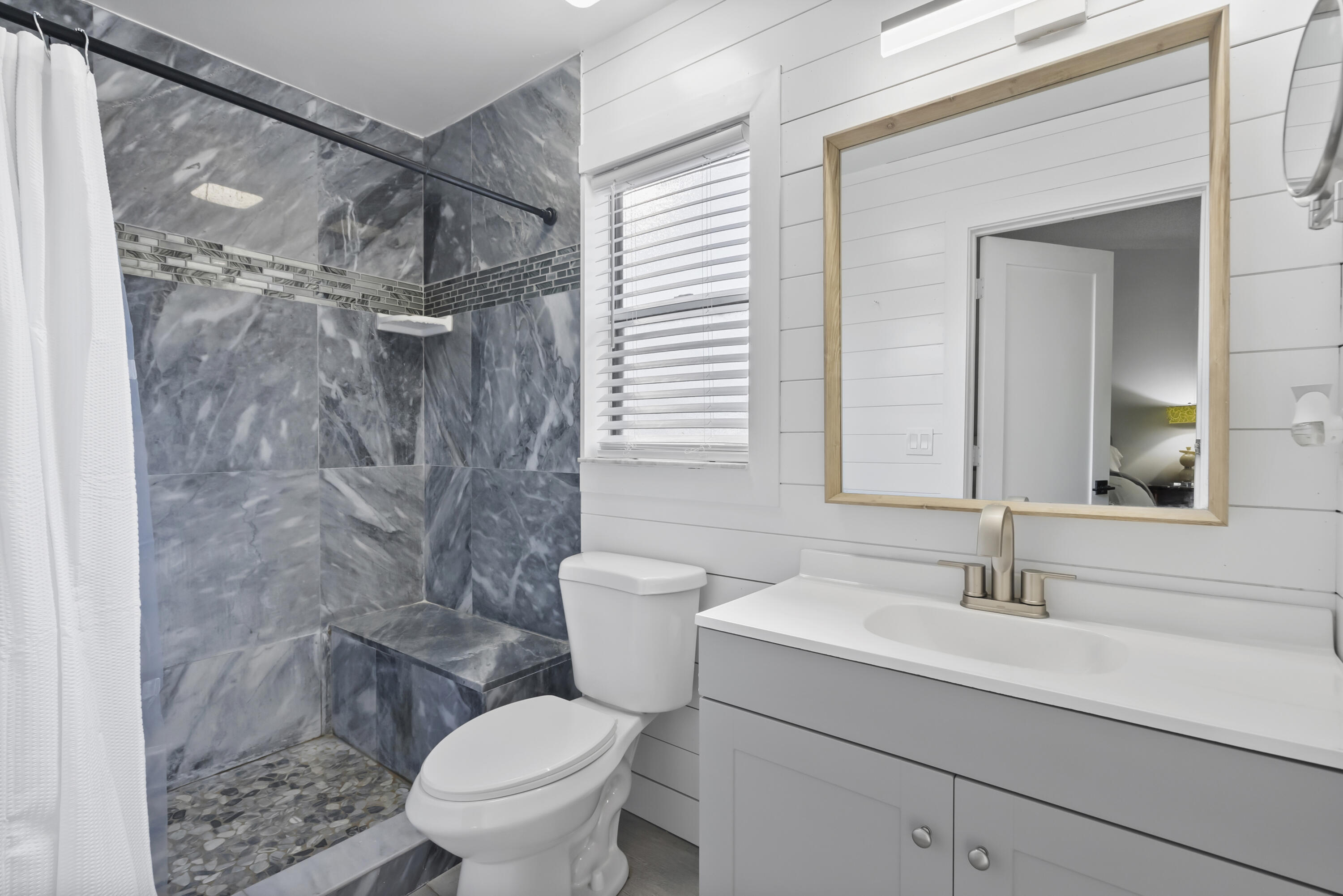 17493 41st Road North The Acreage, FL 33470 - Photo 19 of 45 a bathroom with a sink toilet a mirror and shower