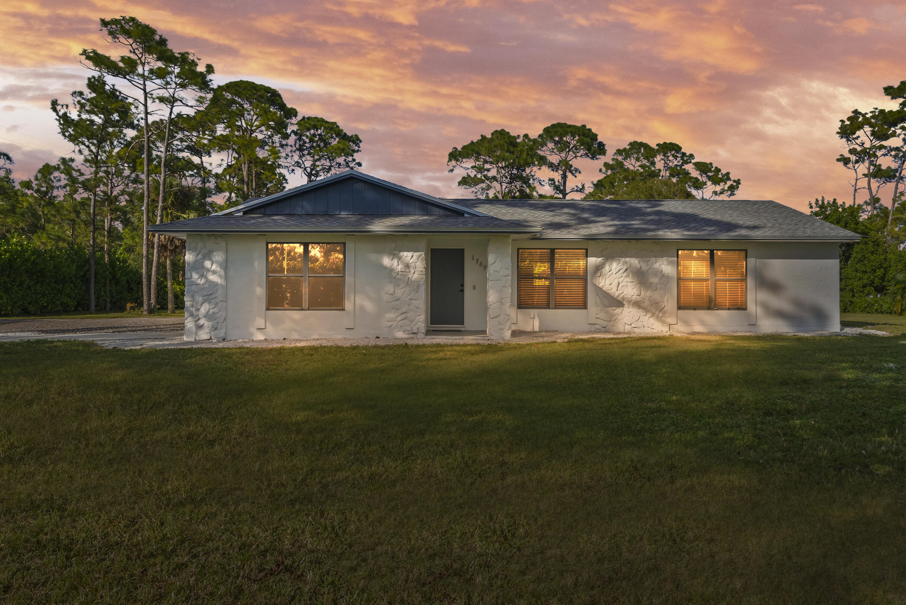 17493 41st Road North The Acreage, FL 33470 - Photo 2 of 45 a front view of house with yard and green space