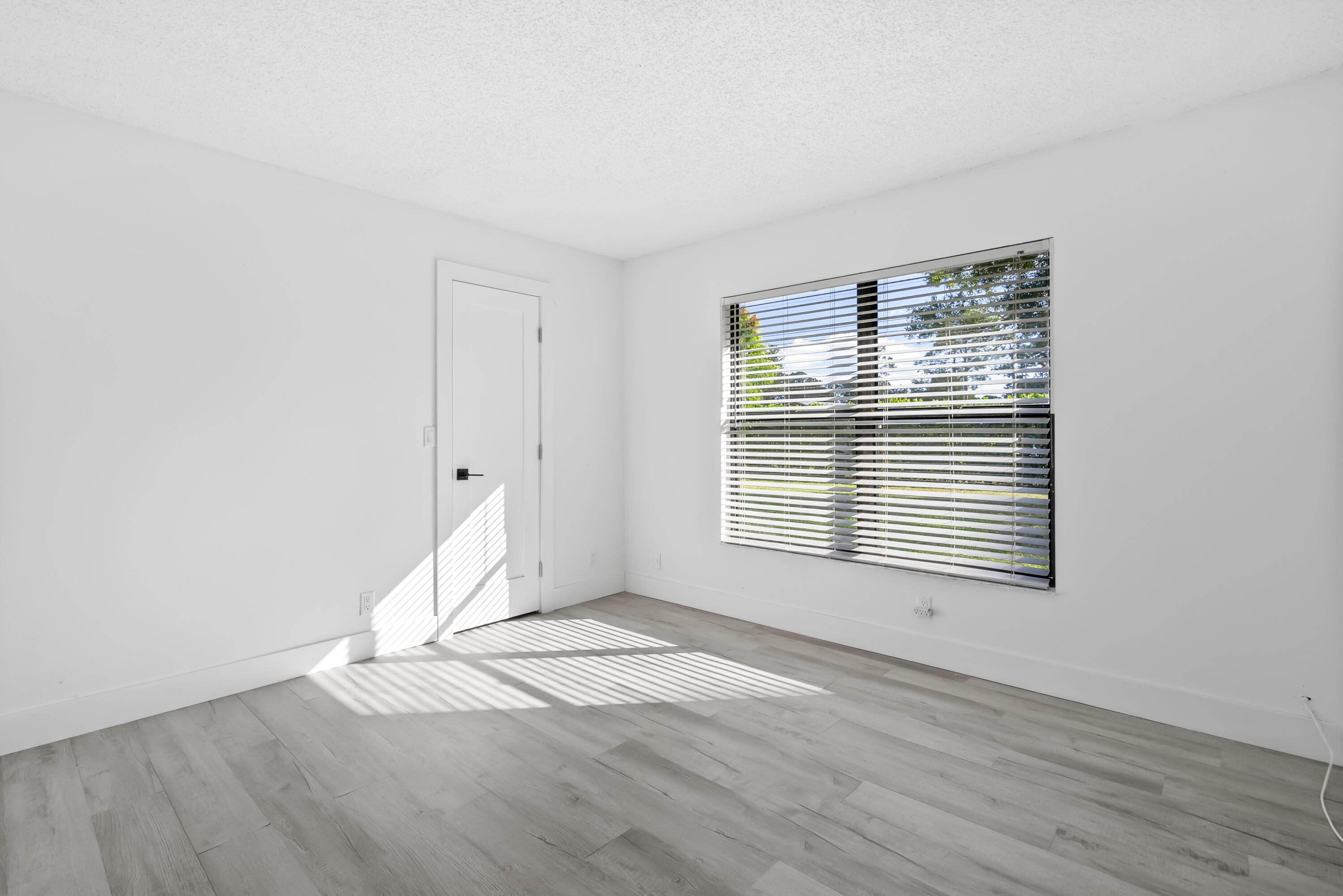 17493 41st Road North The Acreage, FL 33470 - Photo 21 of 45 a view of an empty room with wooden floor and a window