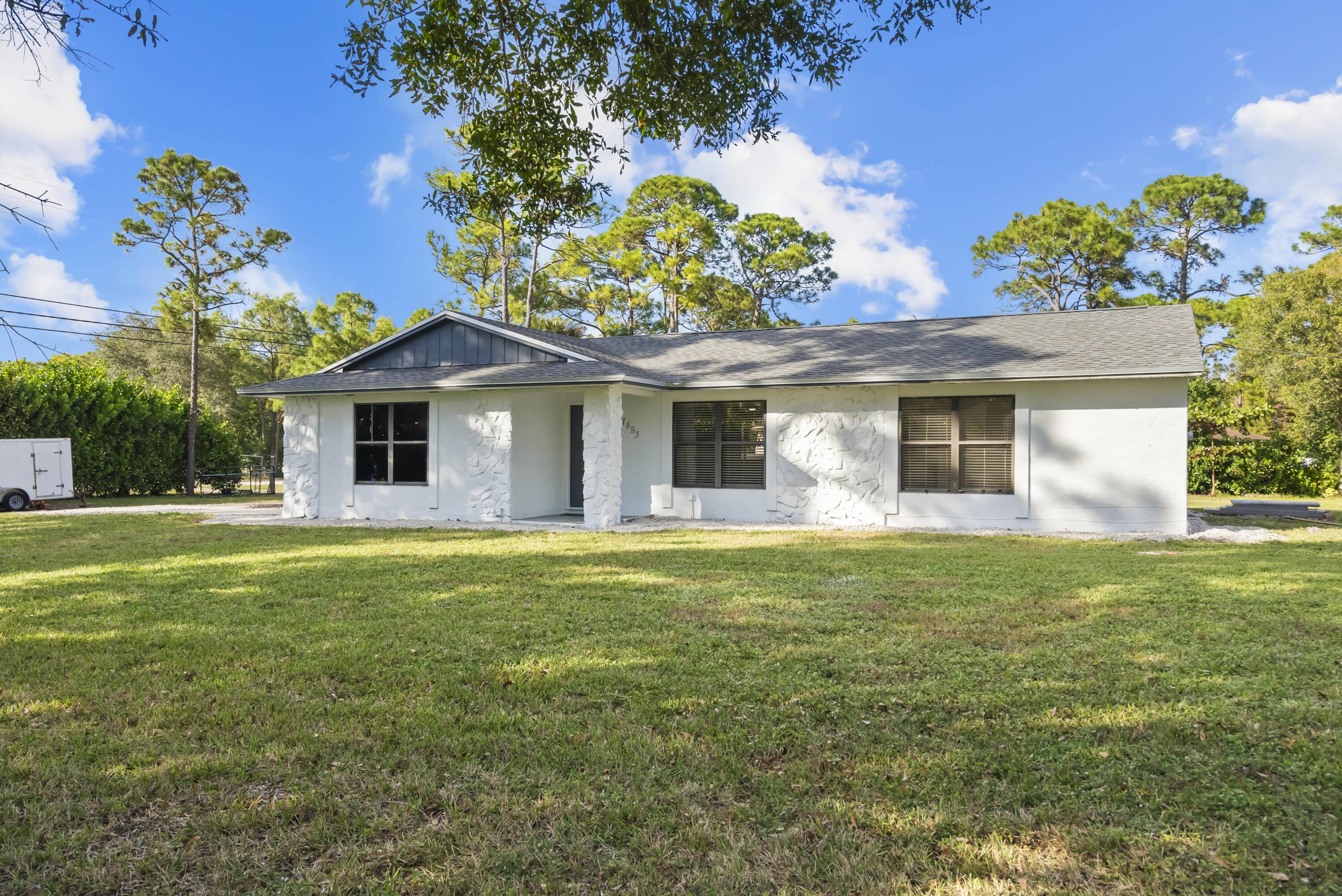 17493 41st Road North The Acreage, FL 33470 - Photo 3 of 45 a front view of a house with a garden