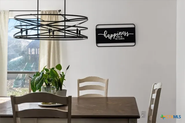 a living room with furniture a potted plant and a chandelier