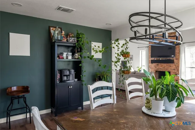 a dining room with furniture potted plants and wooden floor