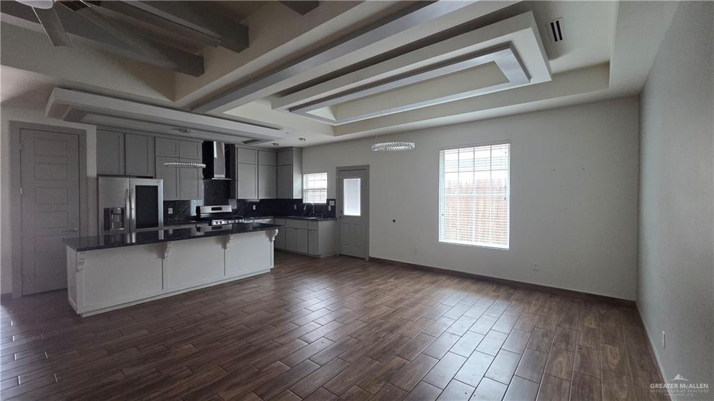 419 North 17th Street, Unit 2 McAllen, TX 78501 - Photo 4 of 10 a kitchen with stainless steel appliances kitchen island wooden floors and white walls