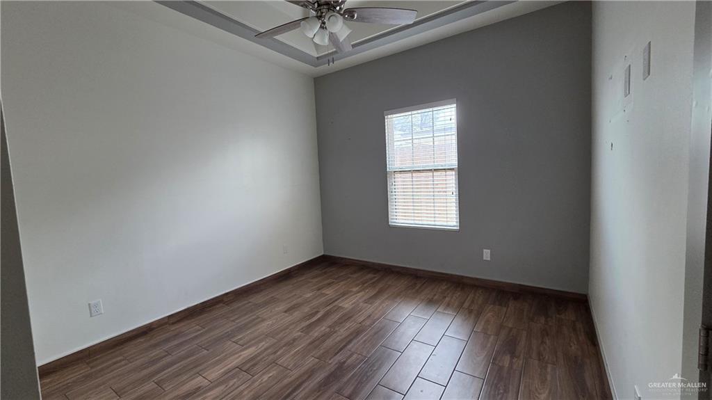 419 North 17th Street, Unit 2 McAllen, TX 78501 - Photo 9 of 10 an empty room with wooden floor chandelier fan and windows