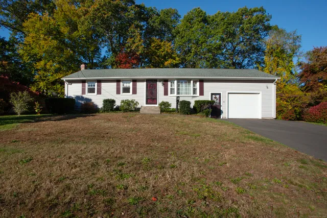 a front view of a house with a yard and trees