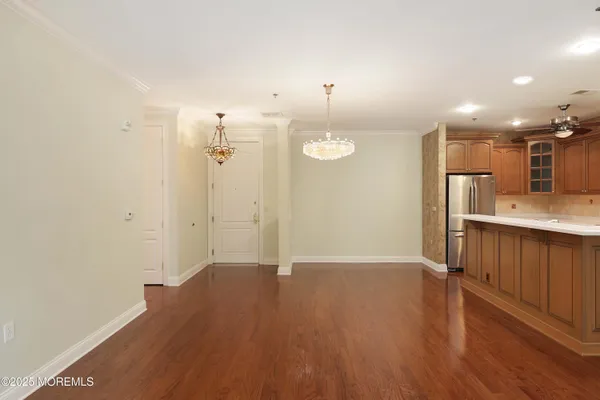 a kitchen with kitchen island granite countertop wooden cabinets and refrigerator