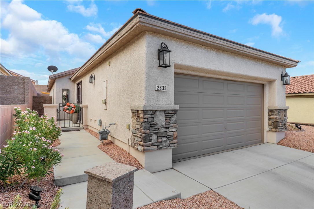 2635 Dirleton Place Henderson, NV 89044 - Photo 4 of 50 Stucco exterior siding and stone veneer accents complement the paved driveway and neat landscaping.