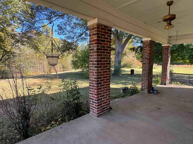 a view of a porch with furniture and a yard
