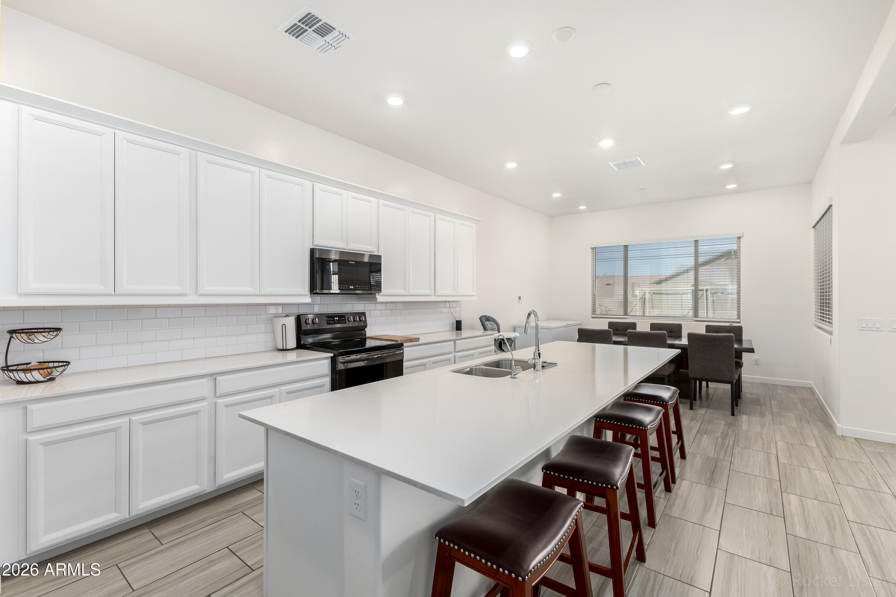 23929 North 166th Lane Surprise, AZ 85387 - Photo 7 of 23 a kitchen with a sink a stove and chairs