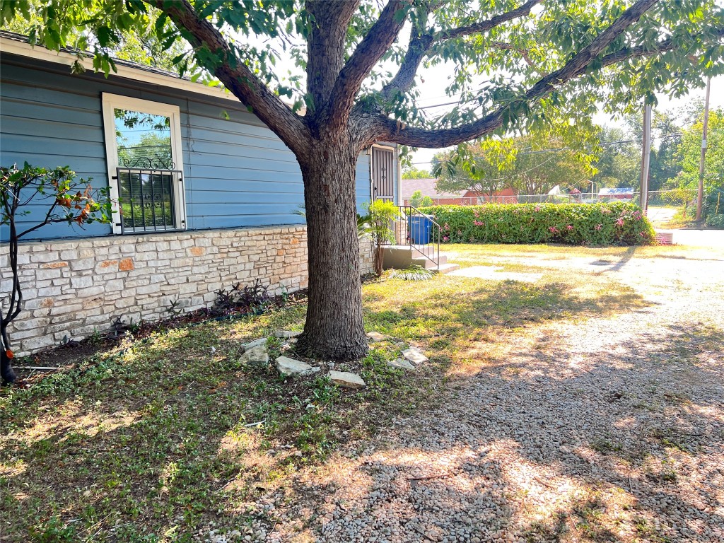 1114 Tillery Street, Unit A Austin, TX 78702 - Photo 3 of 8 a view of a yard with plants and a large tree