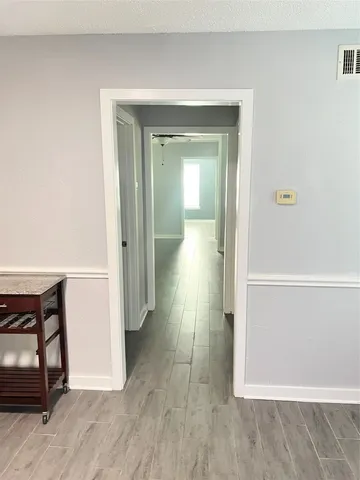 a view of a hallway with wooden floor and closet