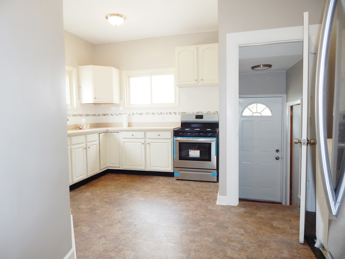 415 North Spring Street Elgin, IL 60120 - Photo 3 of 22 a view of a kitchen with stainless steel appliances granite countertop a stove a sink and a refrigerator with white cabinets