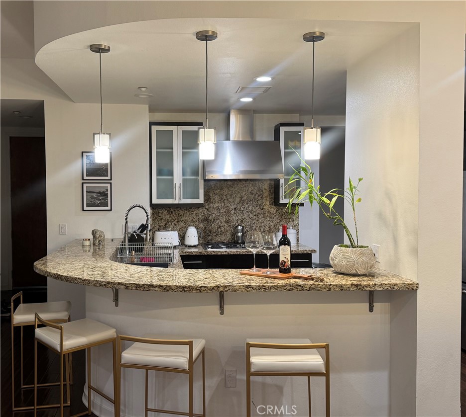 21 Gramercy, Unit 218 Irvine, CA 92612 - Photo 12 of 40 a kitchen with kitchen island granite countertop a sink a counter top space and cabinets