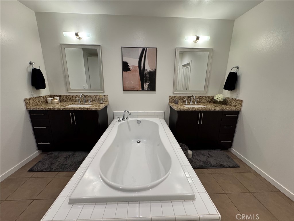 21 Gramercy, Unit 218 Irvine, CA 92612 - Photo 30 of 40 a bathroom with a tub sink and mirror