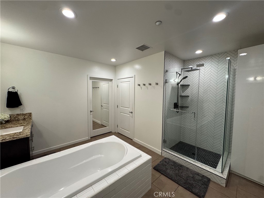 21 Gramercy, Unit 218 Irvine, CA 92612 - Photo 32 of 40 a bathroom with a tub and a shower