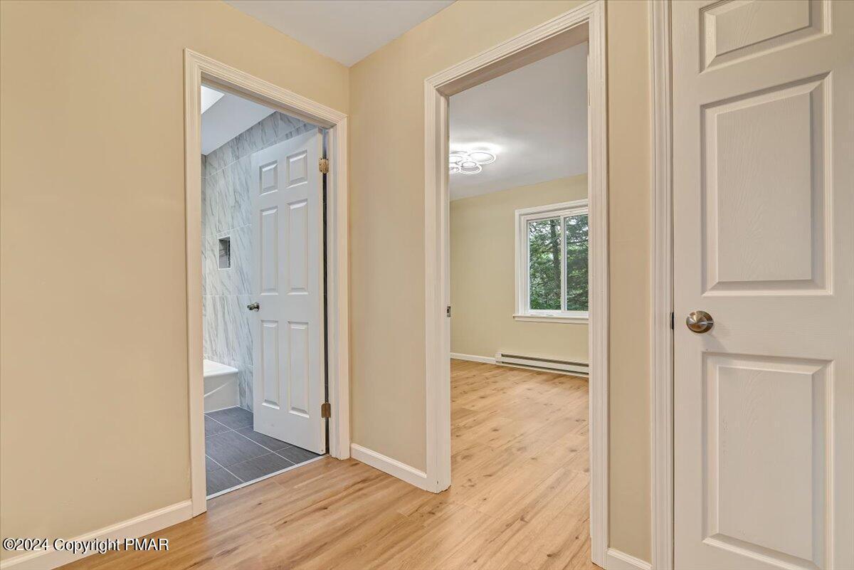 159 Manchester Drive Bushkill, PA 18324 - Photo 25 of 68 a view of a bathroom from a hallway with wooden floor