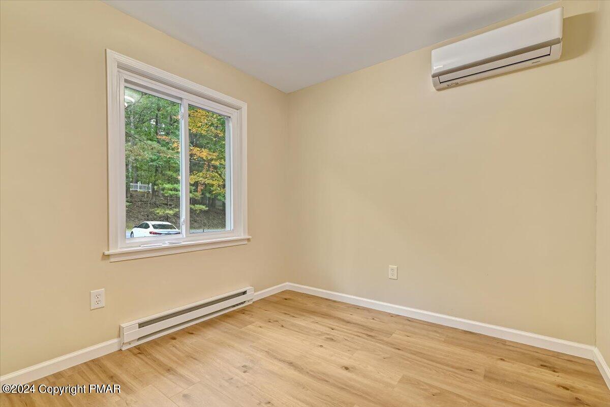 159 Manchester Drive Bushkill, PA 18324 - Photo 28 of 68 an empty room with wooden floor and windows