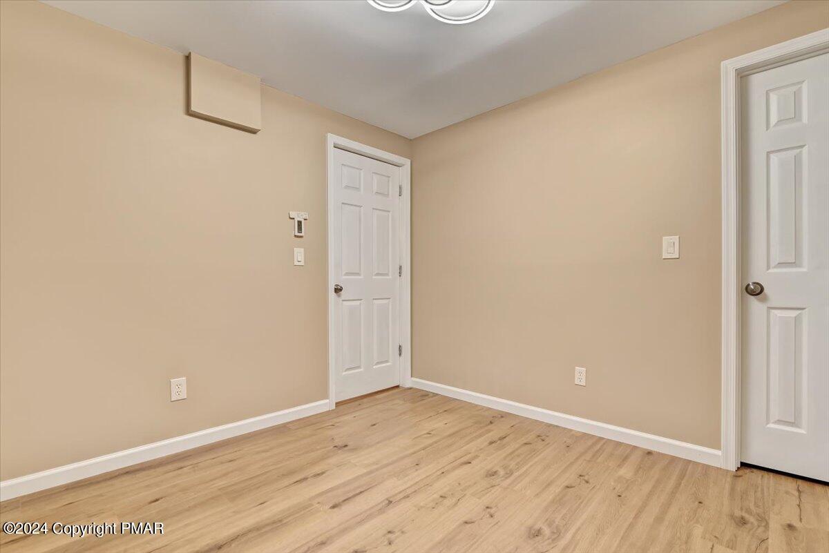 159 Manchester Drive Bushkill, PA 18324 - Photo 37 of 68 an empty room with wooden floor and windows